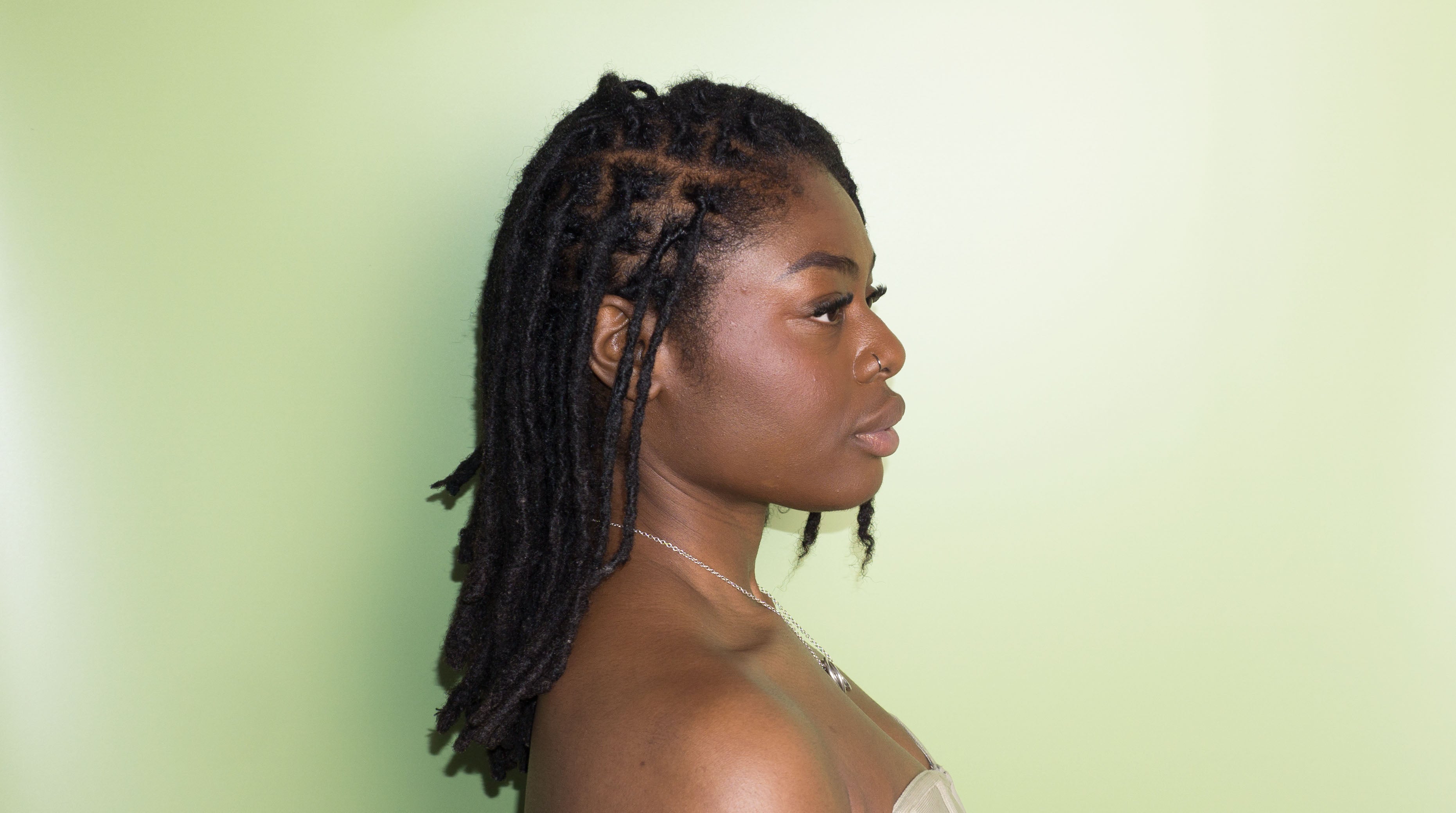 Woman with styled hair against a light green background