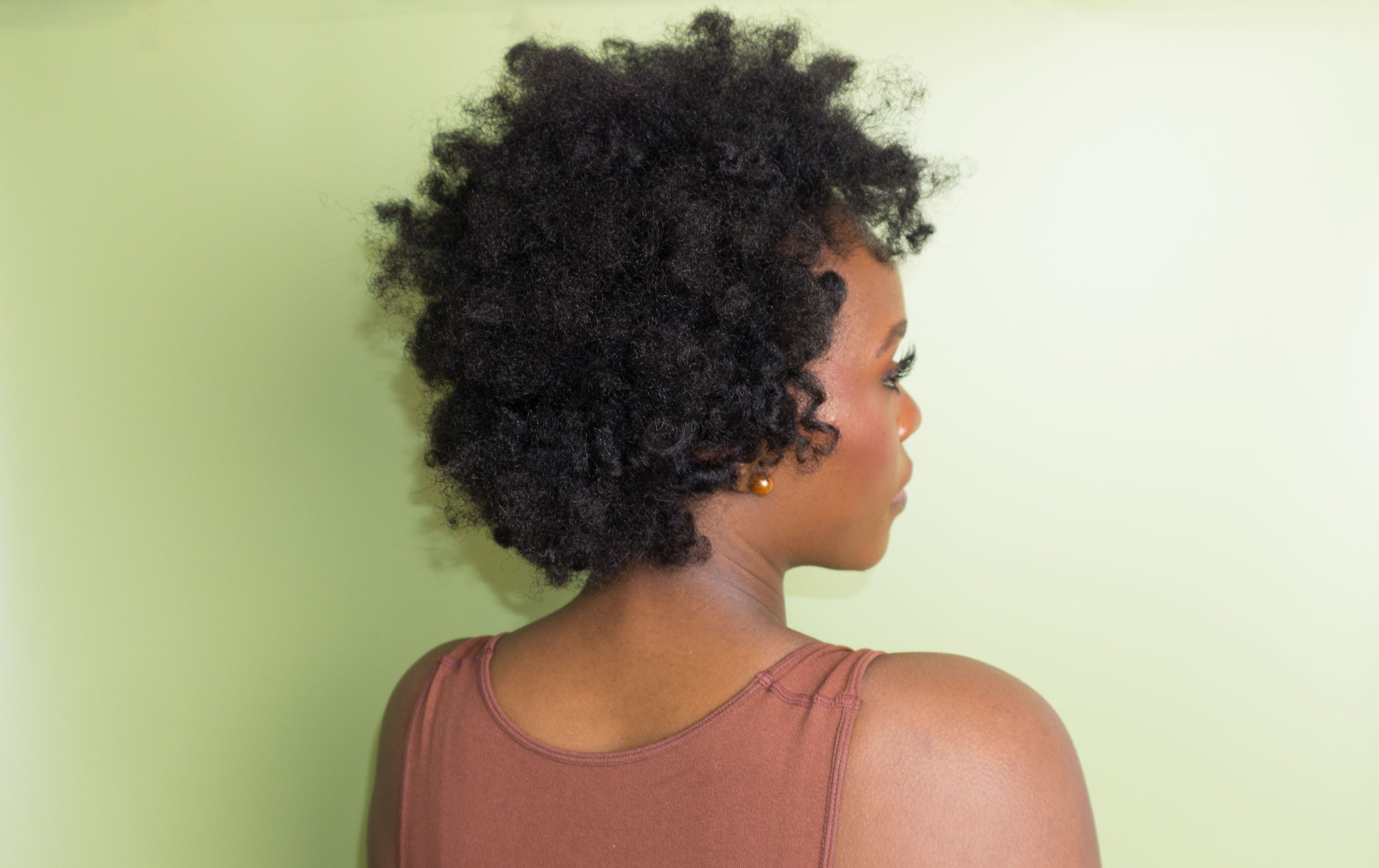 Person with styled hair against a light green background