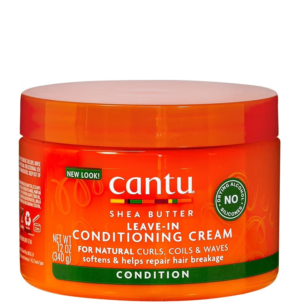 A container of Cantu shea butter leave-in conditioning cream. The container is orange with a green label that features the product name and description.