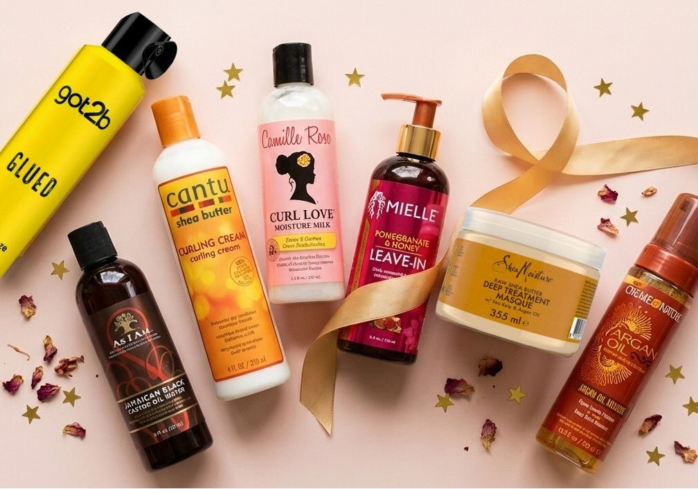Collection of hair care products on a pink background with decorative elements.
