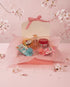 Set of japanese hair products on a pink background with cherry blossoms